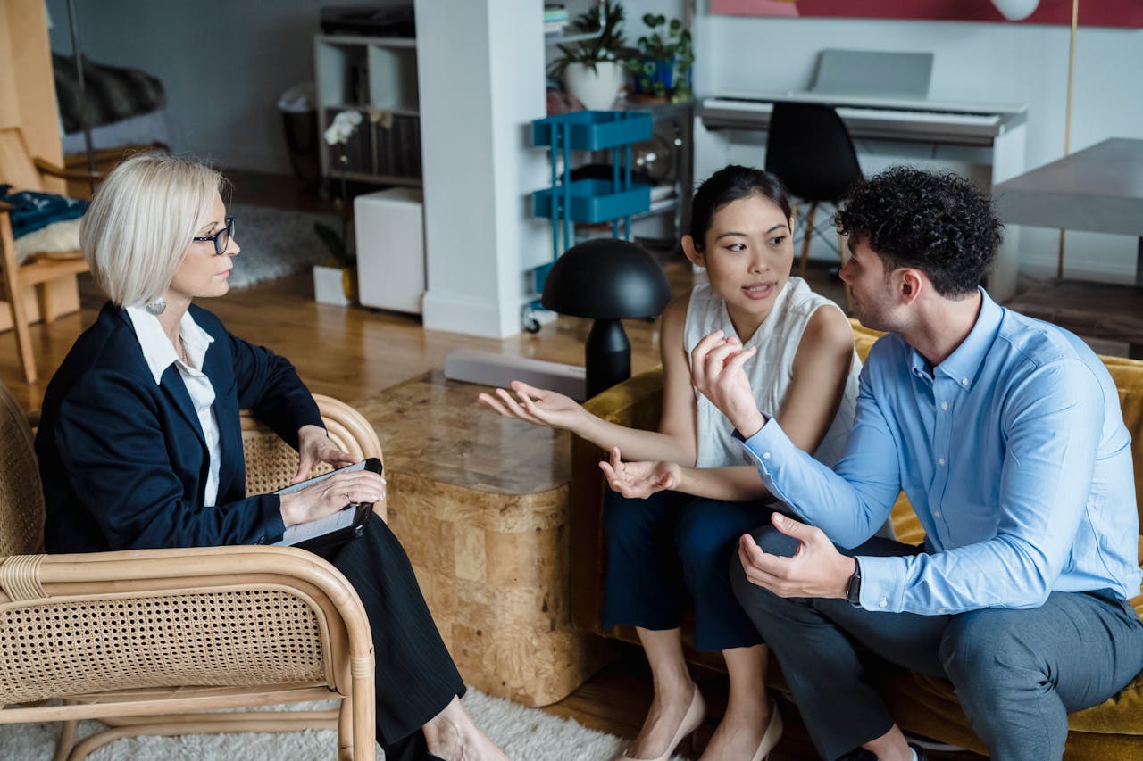 about-01 Couple having a discussion with a counselor in a modern living room setting.