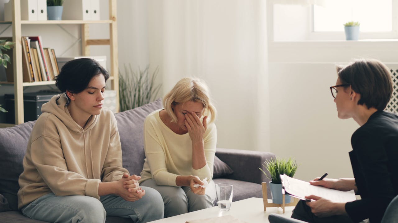 services-cta Emotional family therapy session with a therapist indoors, conveying connection and support.